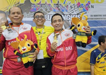 Manajer tim bulu tangkis PWI DKI Jakarta, Budi Tanjung bersama dua atlet bulu tangkis peraih medali emas PORWANAS XIV Banjarmasin.